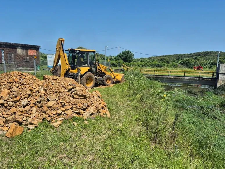 Backhoe loader working beside a water canal